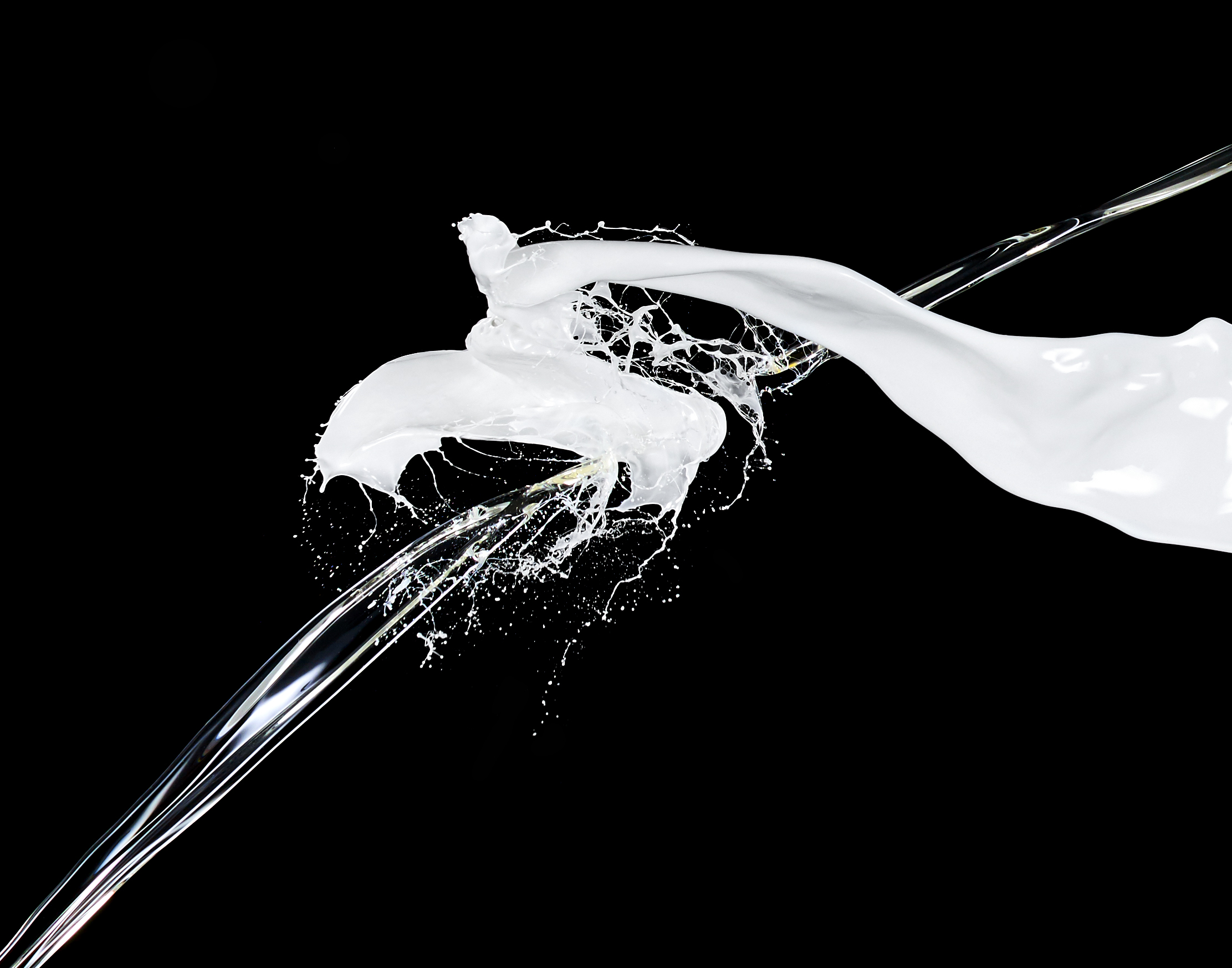 PROPRIETARY CLEAR LIQUID SHOT IN MID AIR WHILE CRASHING THOUGH WHITE PAINT CREATING ABSTRACT SHAPES SHOT BY DAVID FILIBERTI